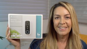 Erin holding Abode video doorbell and smiling.