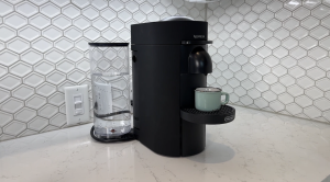 Nespresso Vertuo Plus against white tiled kitchen wall.